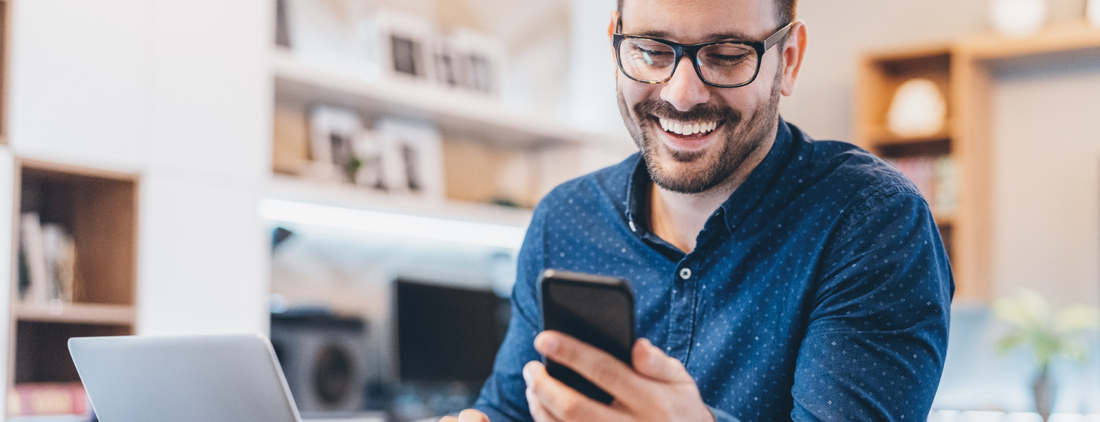 A man using a mobile phone and smiling